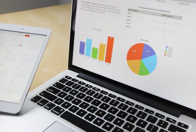 Laptop displaying charts and graphs with tablet calendar for data analysis and planning.